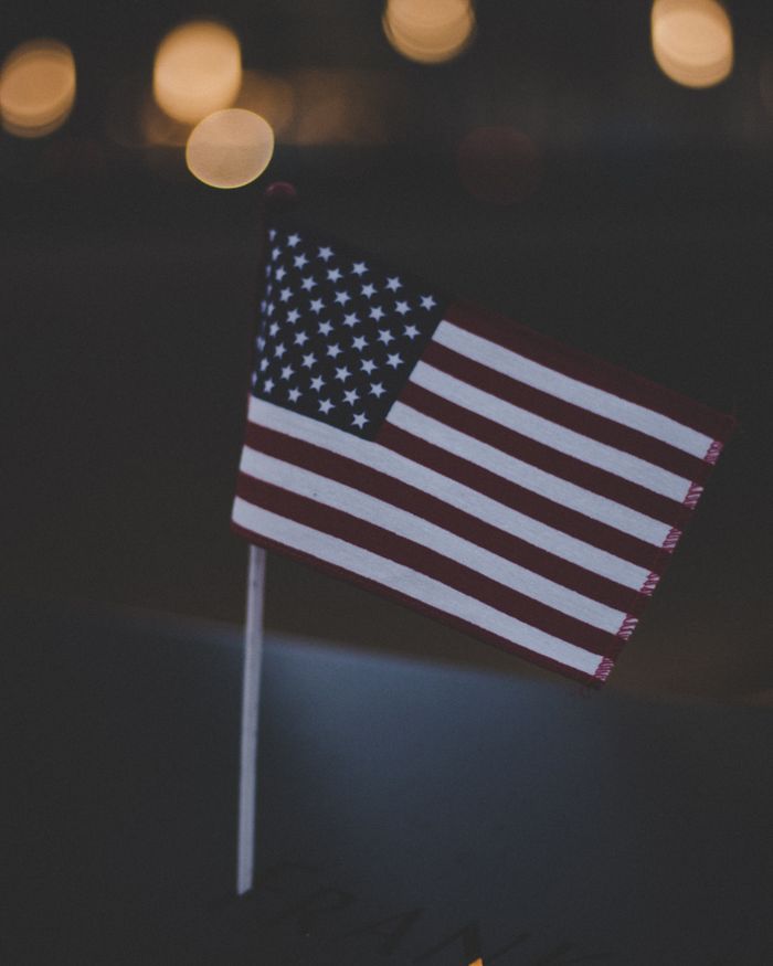 Close-up of the USA flag against bokeh lights, symbolizing patriotism.